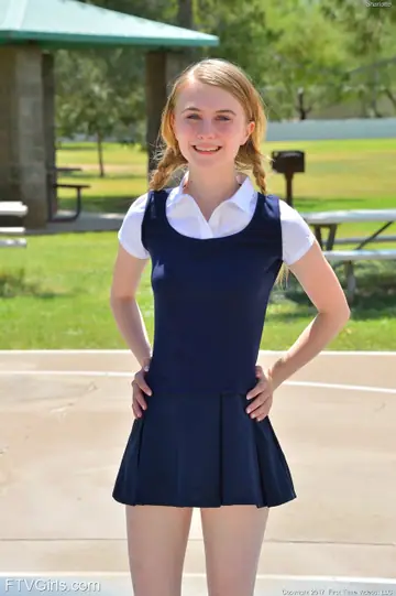 Charlotte Carmen – Skinny Blonde in Uniform Skirt Spreads Outdoors
