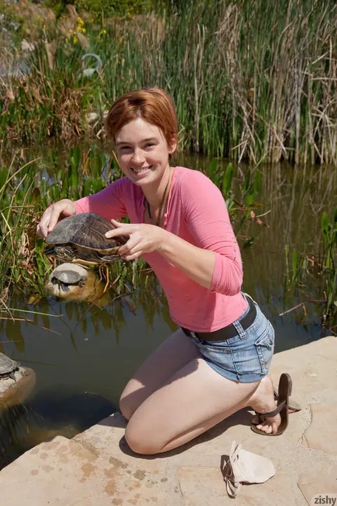 Jodi Taylor: Redhead in Shorts Spreads Her Legs Outdoors – photo 11 of 11